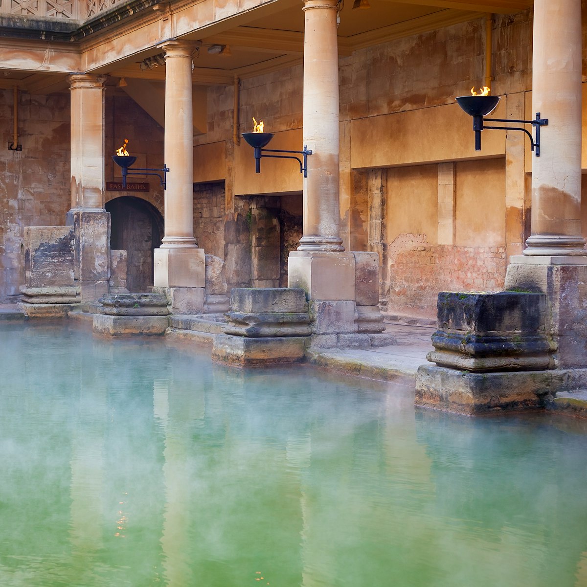 Steam rising off the hot  mineral water in the Great Bath, part of the Roman Baths in Bath, UK